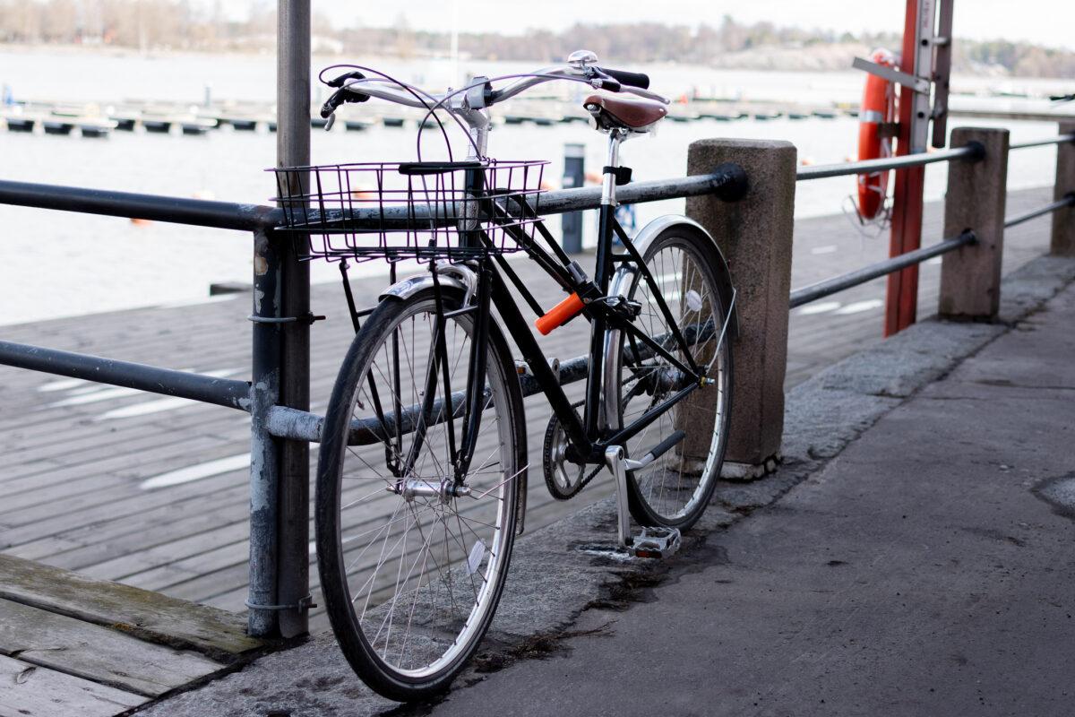 bicycle with a basket on the front is parked on a sidewalk